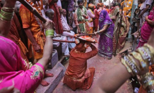 Women from Barsana village hit villagers from Nandgaon with a wooden stick during the Lathmar Holi